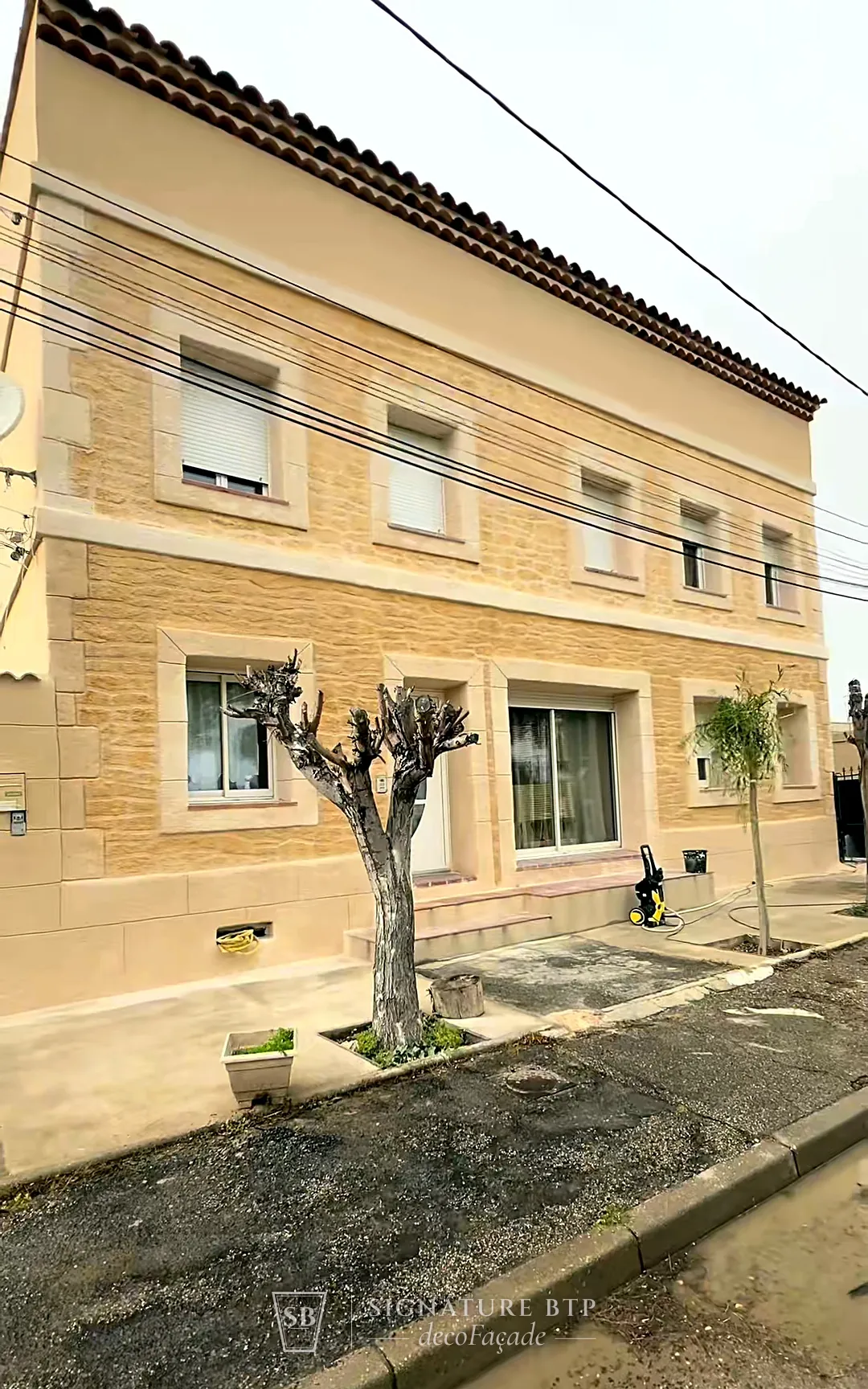 Maison à étage habillée d’un enduit sculpté façon pierre de taille, encadrements de fenêtres clairs